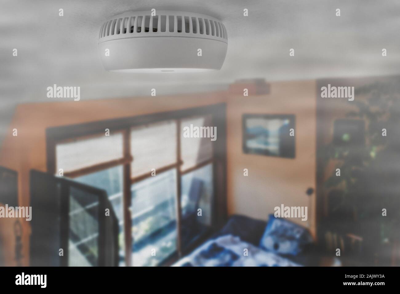 Domestico allarme fumo / alimentato a batteria per il rilevatore di fumo sul soffitto della camera riempita con fumo dal fuoco a casa Foto Stock