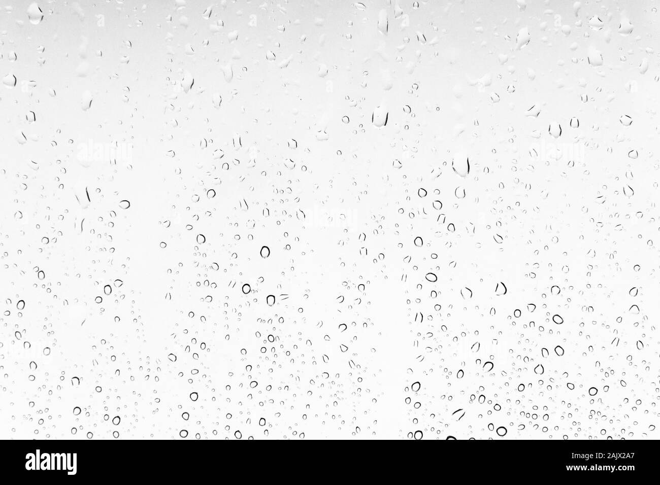Gocce d'acqua sullo sfondo di una finestra. Texture bianche di pioggia Foto Stock