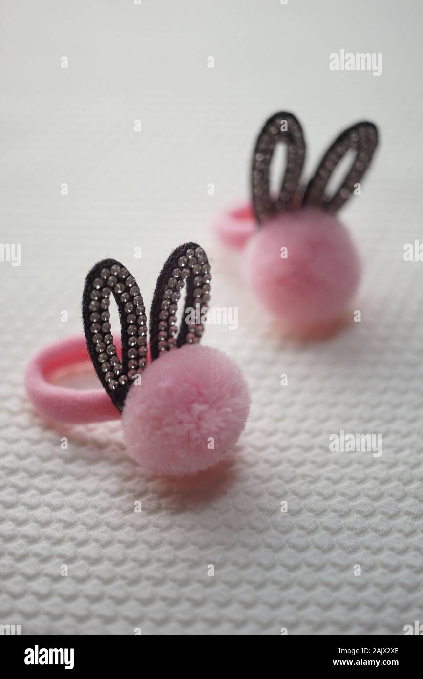 Due scrunchy per capelli con orecchie nero in strass e una morbida pompon rosa. Foto Stock