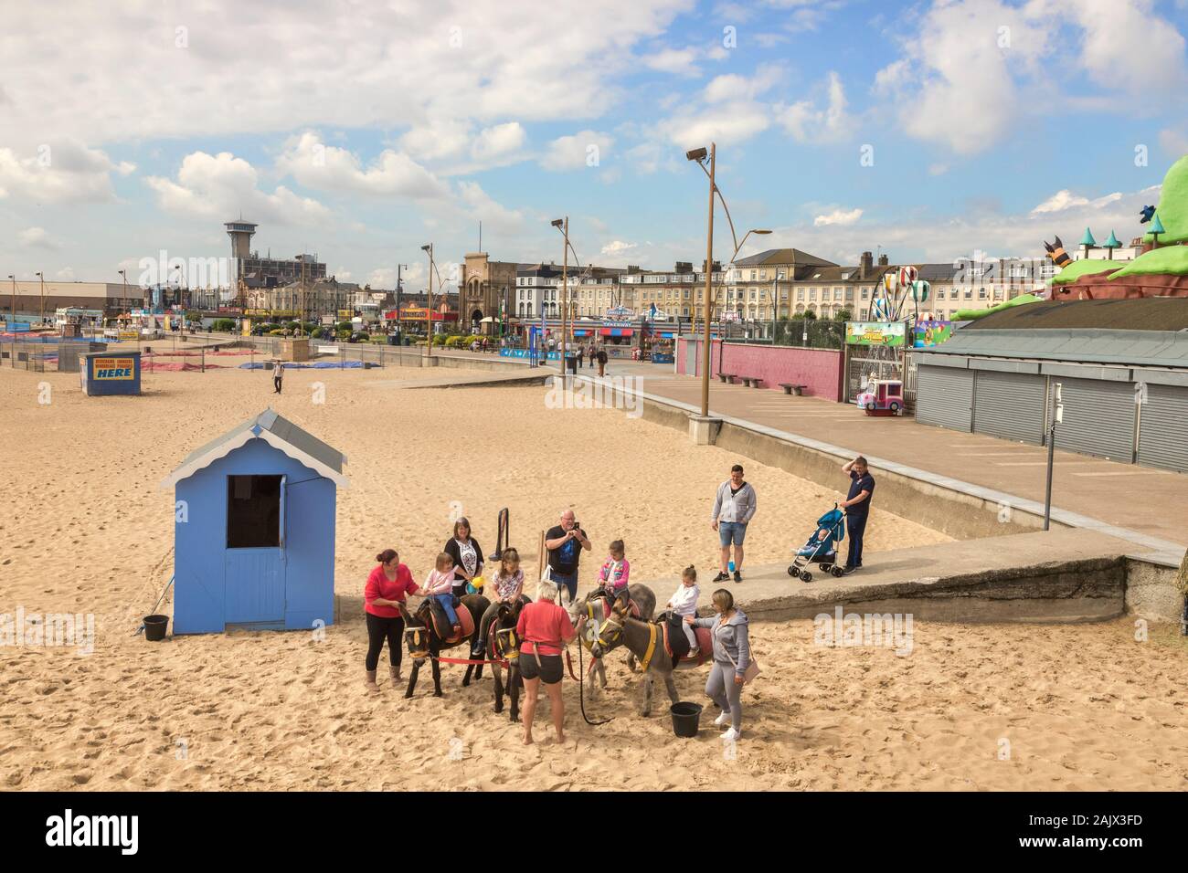 26 Giugno 2019: Great Yarmouth, Norfolk, Regno Unito - Bambini equitazione asini in spiaggia con i genitori ad assistere. Foto Stock