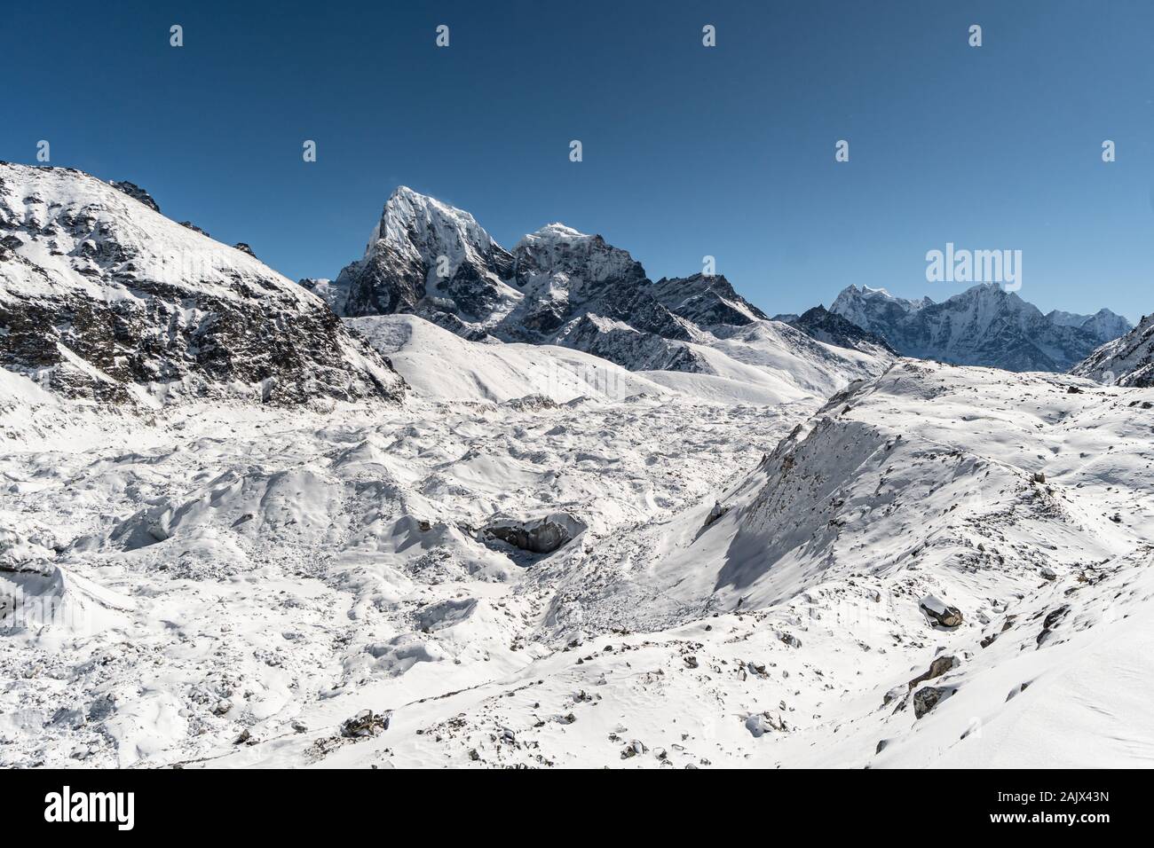 Il ghiacciaio Ngozumpa con il picco Cholatse in background durante una giornata invernale in Da Gokyo in Himalaya in Nepal Foto Stock
