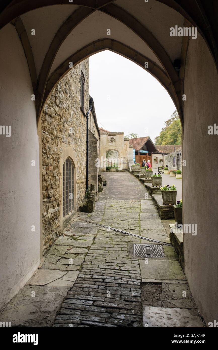 Arch e il percorso per il negozio di abbazia e l'ingresso visto dalla strada. Glastonbury, Somerset, Inghilterra, Regno Unito, Gran Bretagna Foto Stock