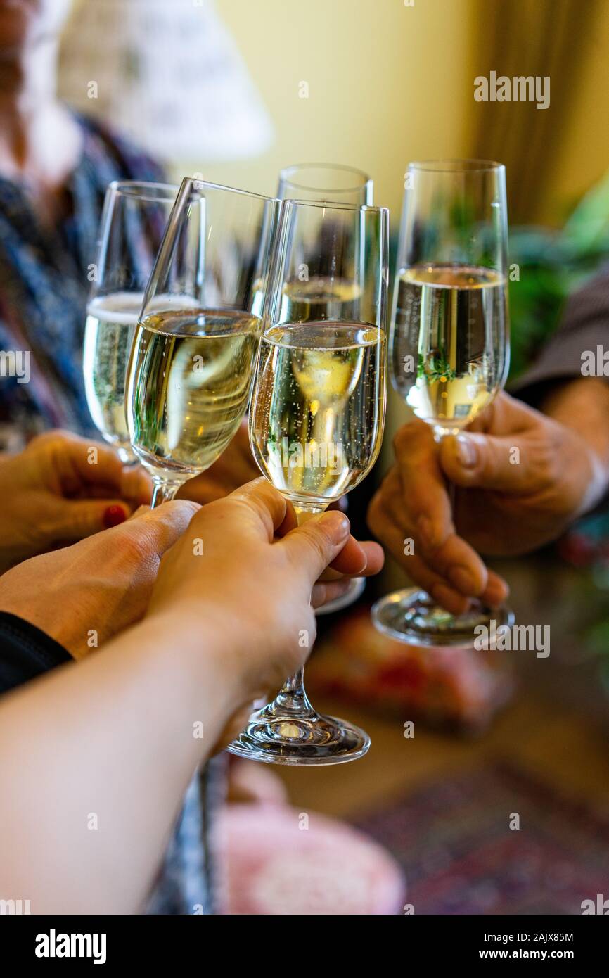 La tostatura con bicchieri di champagne in interni ritratto verticale . Foto Stock