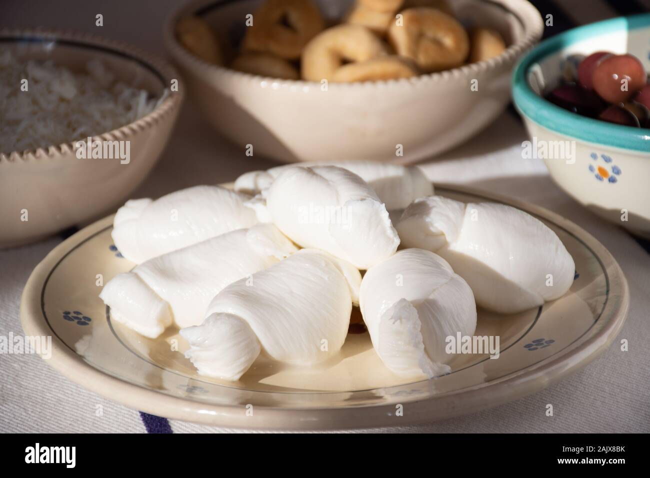 Mozzarella Fresca, tradizionalmente meridionali italiani formaggio di latte italiano dalla pasta filata metodo in un tradizionale piatto di terracotta Foto Stock