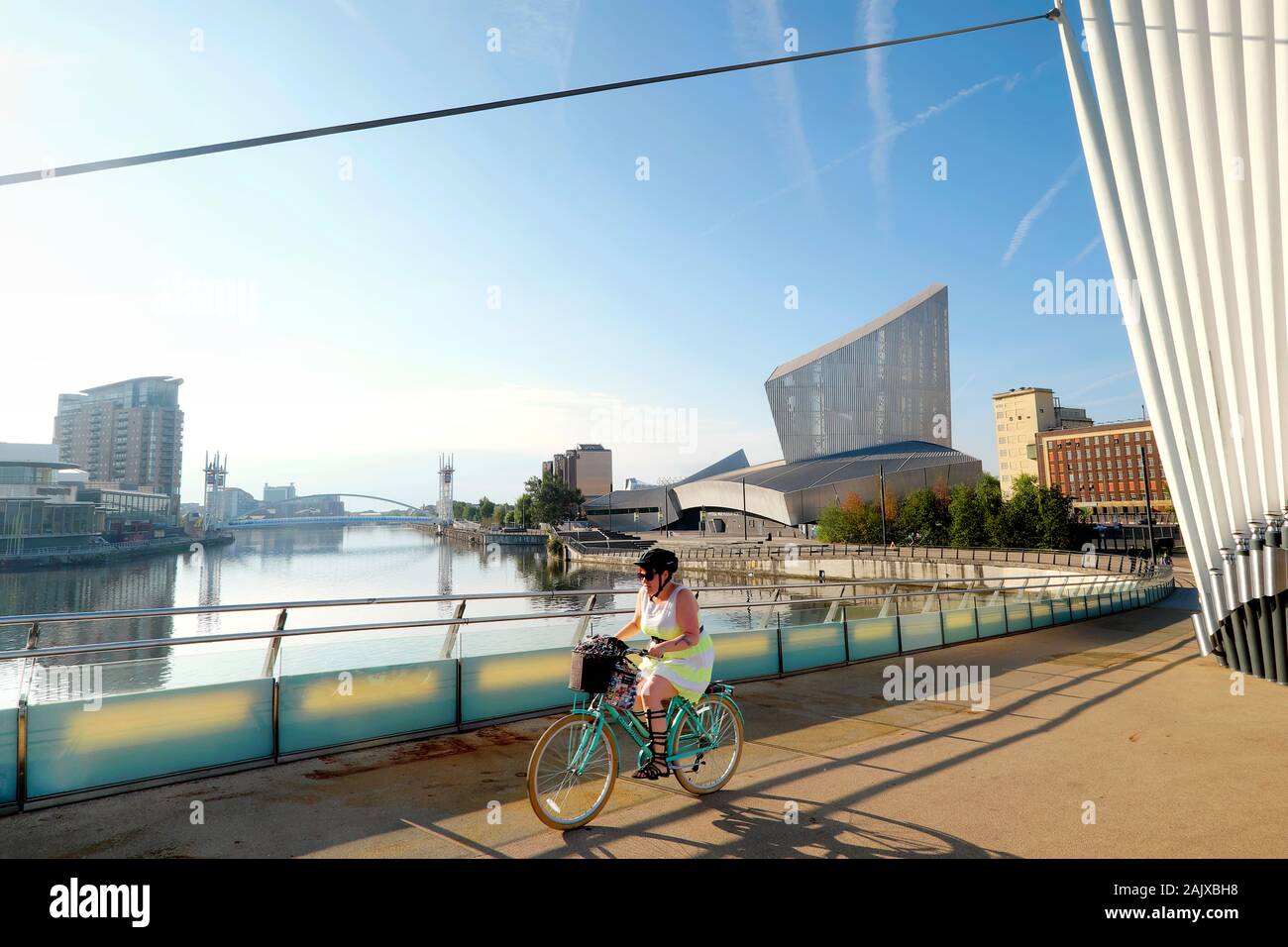 Ciclista attraversando Media City passerella, Salford Quays, Greater Manchester, Inghilterra, Regno Unito, Europa Foto Stock