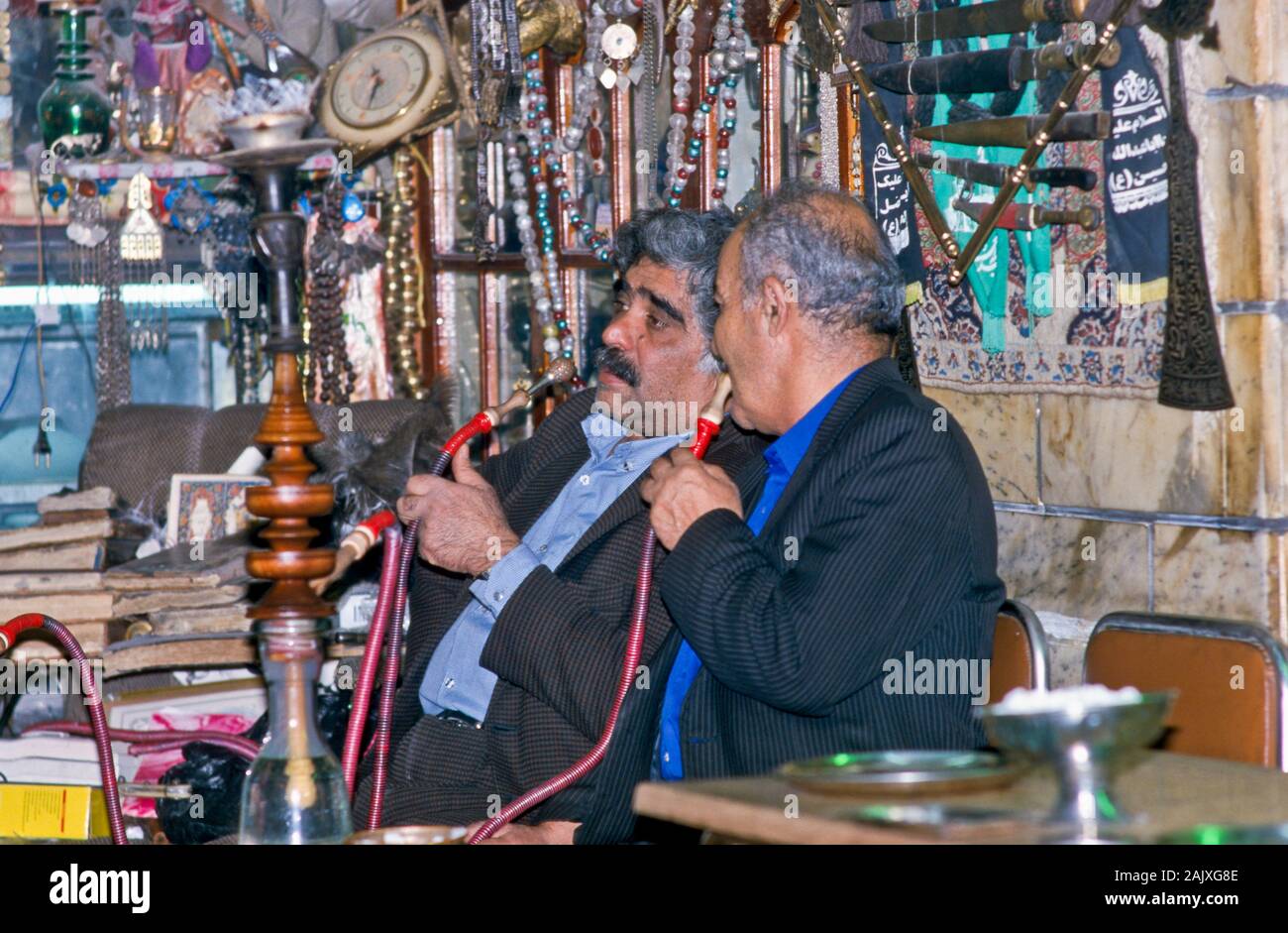 Gli uomini fumatori waterpipe in una piccola locanda nel bazaar di Isfahan Foto Stock