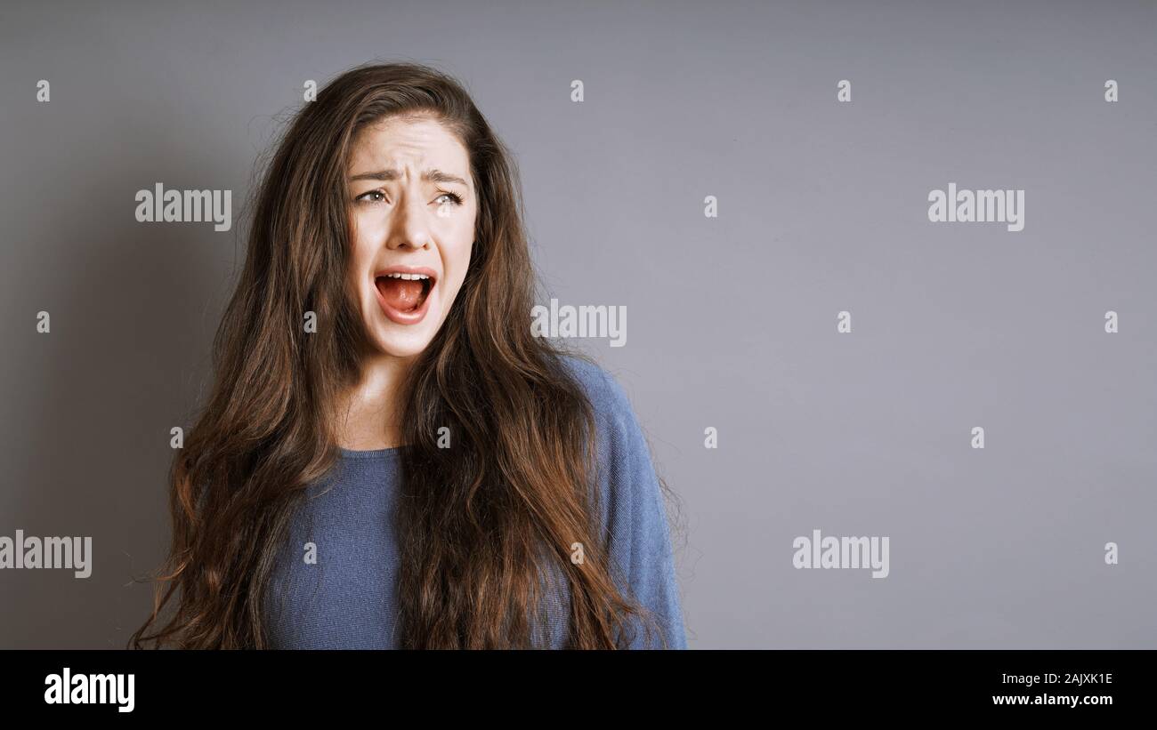 Giovane donna urlare o gridare con la sua bocca aperta Foto Stock