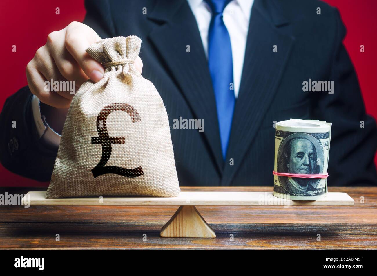 Un uomo mette una lira sterlina GBP sacco di denaro sulle scale di fronte al dollaro. Tasso di cambio, il confronto degli indicatori economici. Gli investimenti in forei Foto Stock