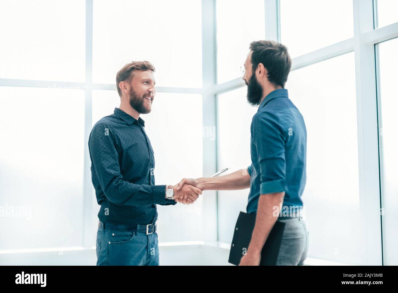 Sorridente la gente di affari si stringono la mano in ufficio. Foto Stock