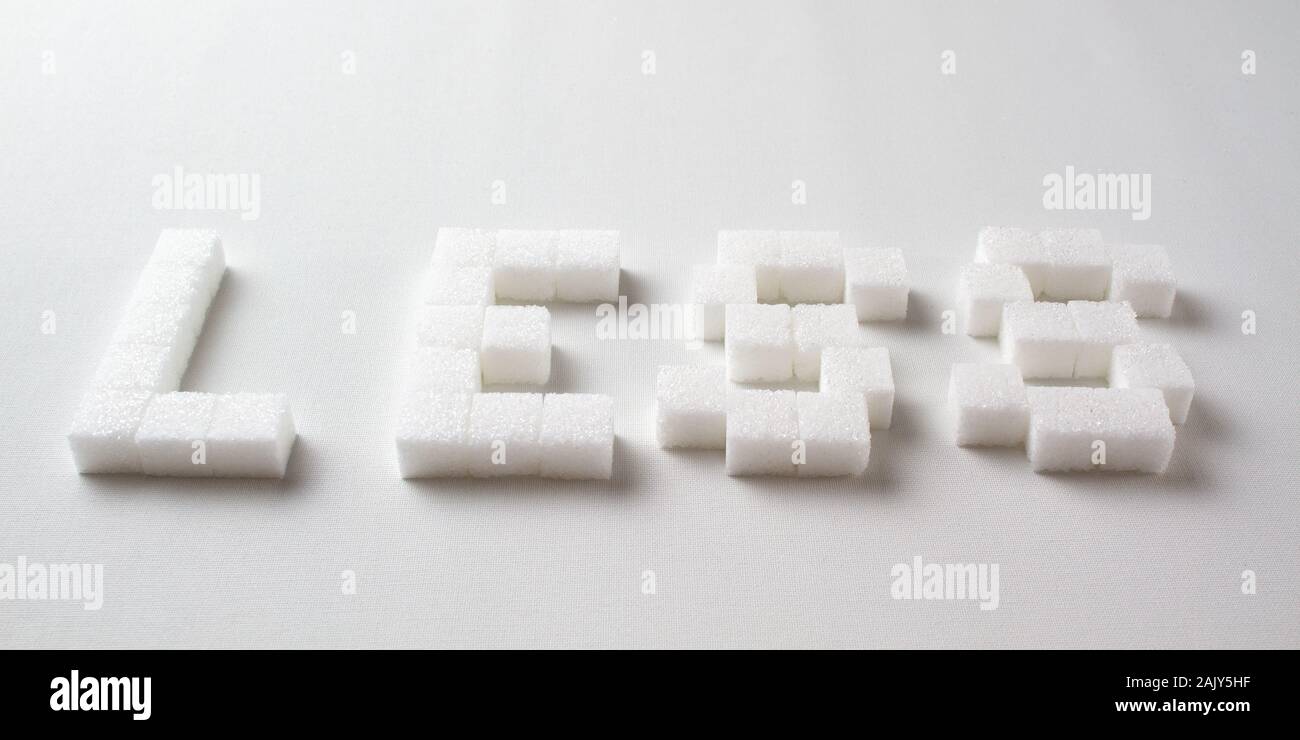'Less' scritto con pixel art lettere fatte di zollette di zucchero su sfondo bianco Foto Stock