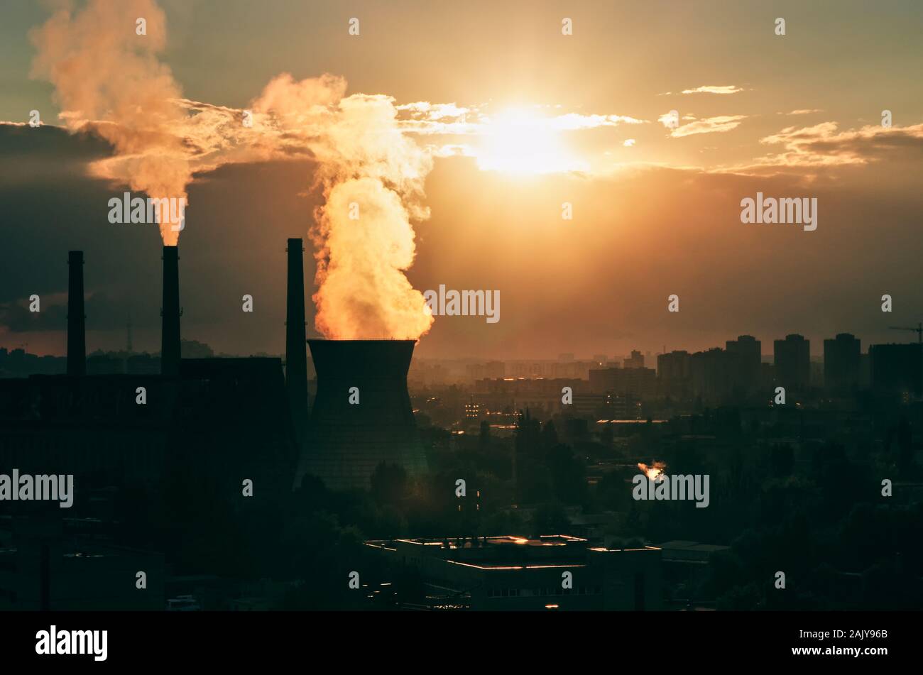 Paesaggio urbano industriale di Kiev, Ucraina. Vapore dalla torre di raffreddamento di un impianto di centrali a carbone e il fumo dai camini. Tramonto Foto Stock