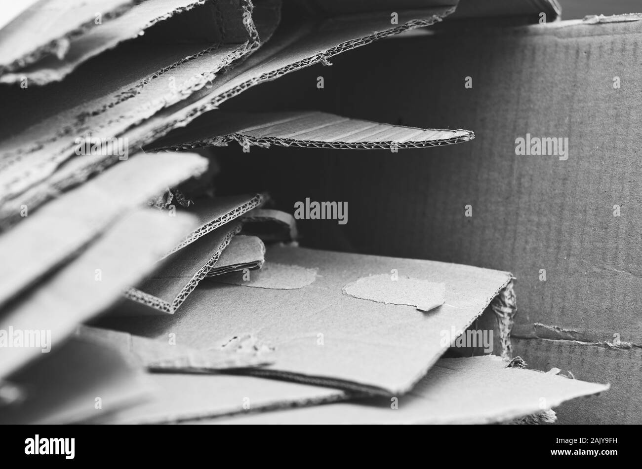 Imballaggi in cartone ondulato, tagliato a doppia parete a bordo di bit e pezzi. Scarti di scatole di cartone. In bianco e nero Foto Stock