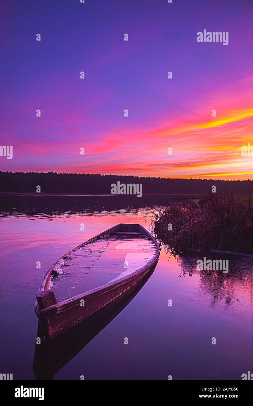 La pesca in barca su un fiume calmo di Sunrise Foto Stock