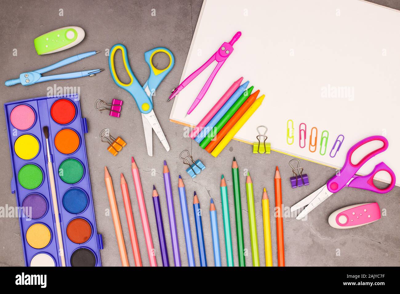 Si torna a scuola - Bianco blocco di trascinamento e la scuola di arte e forniture su sfondo grigio Foto Stock