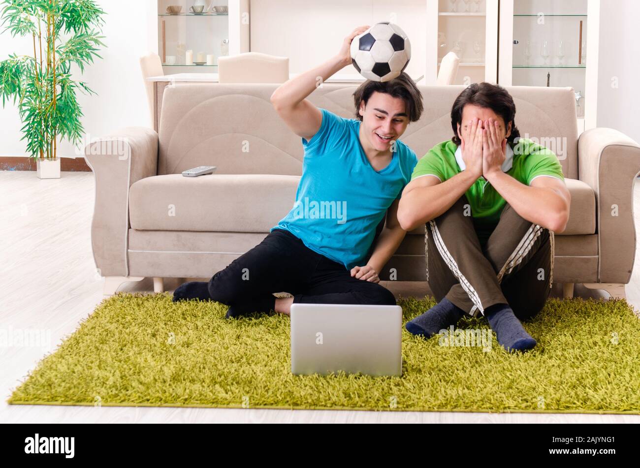 Gli amici guardare il calcio a casa Foto Stock