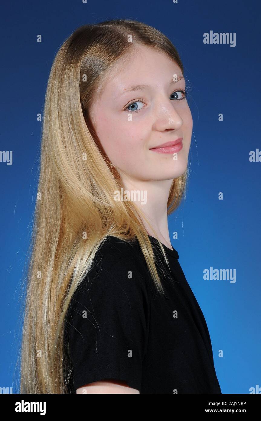 Bella bionda pelose Caucasian ragazza adolescente in una t-shirt nera isolata su un brillante sfondo graduata Foto Stock