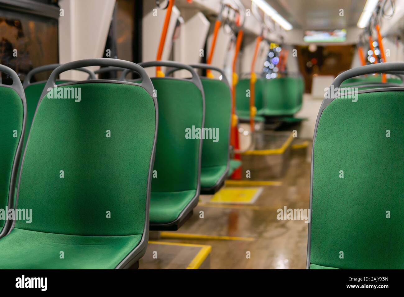 Parzialmente sfocato interno di una bassa - Pavimento cabina del tram con sedie in fila in primo piano Foto Stock