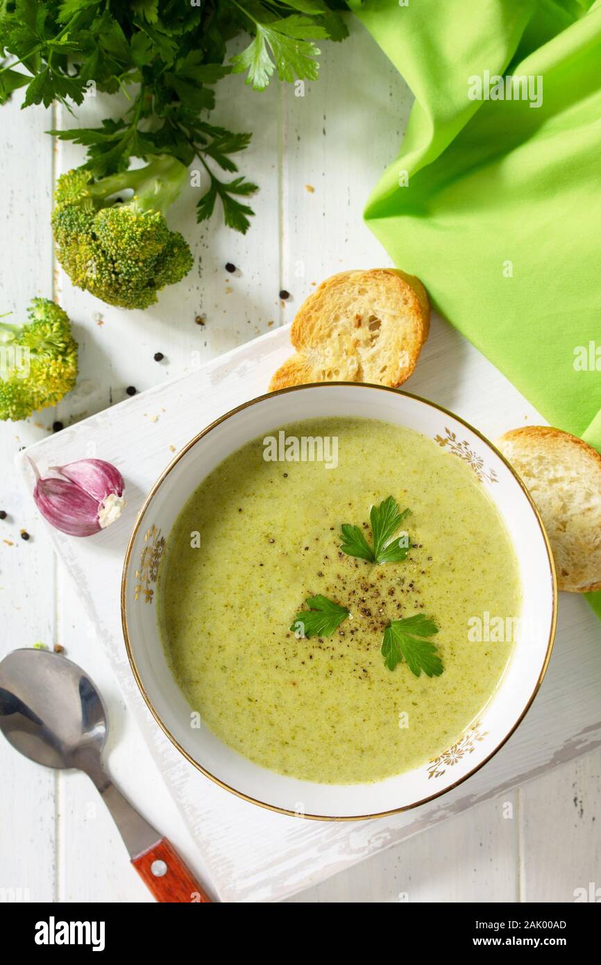 Menù dietetici. Mangiare sano concetto. Purea di zuppa di broccoli con crostini di aglio su un di legno bianco tavolo da cucina. Vista superiore piatta. laici Foto Stock