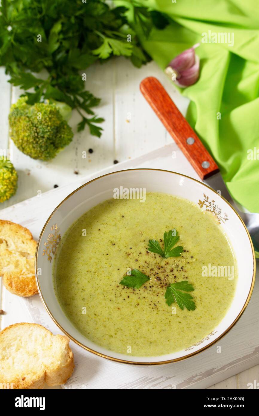 Menù dietetici. Mangiare sano concetto. Purea di zuppa di broccoli con crostini di aglio su un di legno bianco tavolo da cucina. Foto Stock