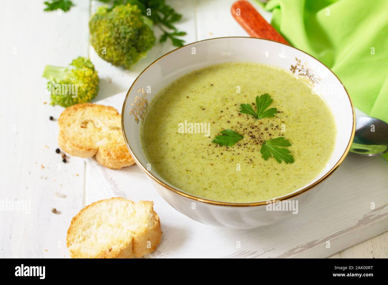 Menù dietetici. Mangiare sano concetto. Purea di zuppa di broccoli con crostini di aglio su un di legno bianco tavolo da cucina. Foto Stock