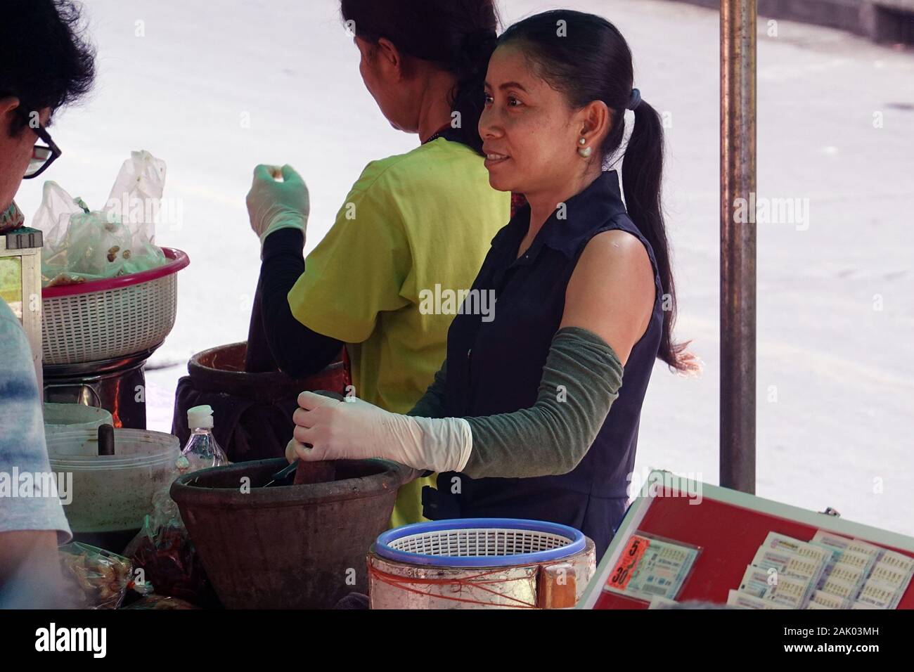 Venditore ambulante rendendo Som tam, una verde insalata di papaia. Foto Stock