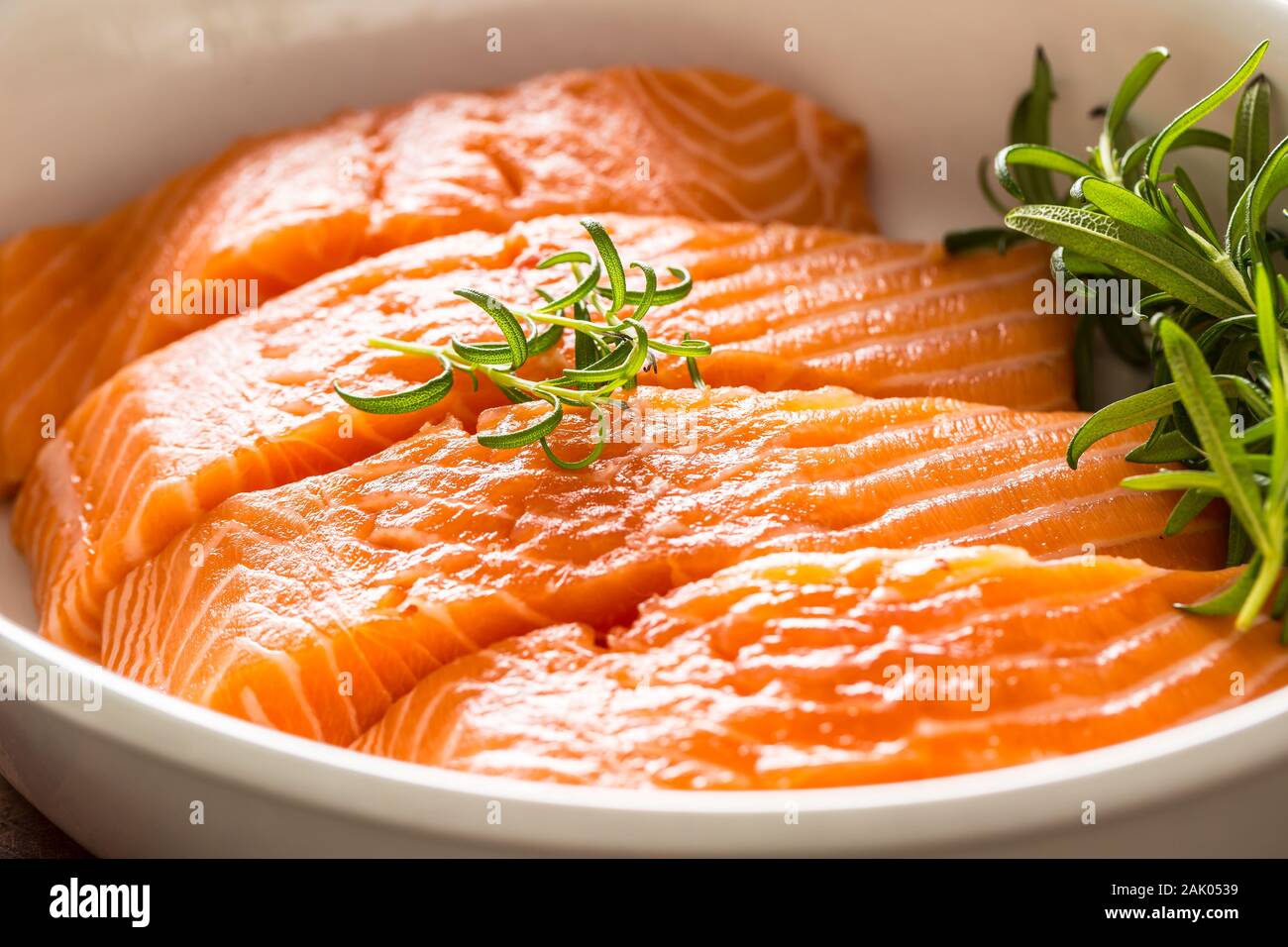 Materie di filetti di salmone con erbe aromatiche in una teglia Foto Stock