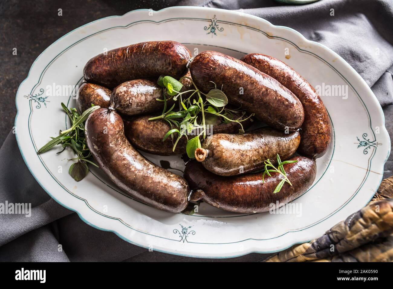Salsicce arrostite in padella con rosmarino. Tradizionale cibo europeo il bratwurst jaternice o jitrnice Foto Stock