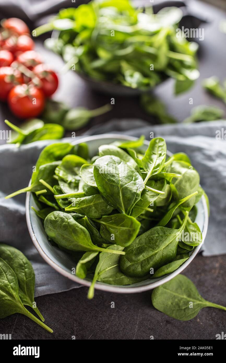 Fresh baby spinaci in recipiente scuro sul tavolo da cucina Foto Stock
