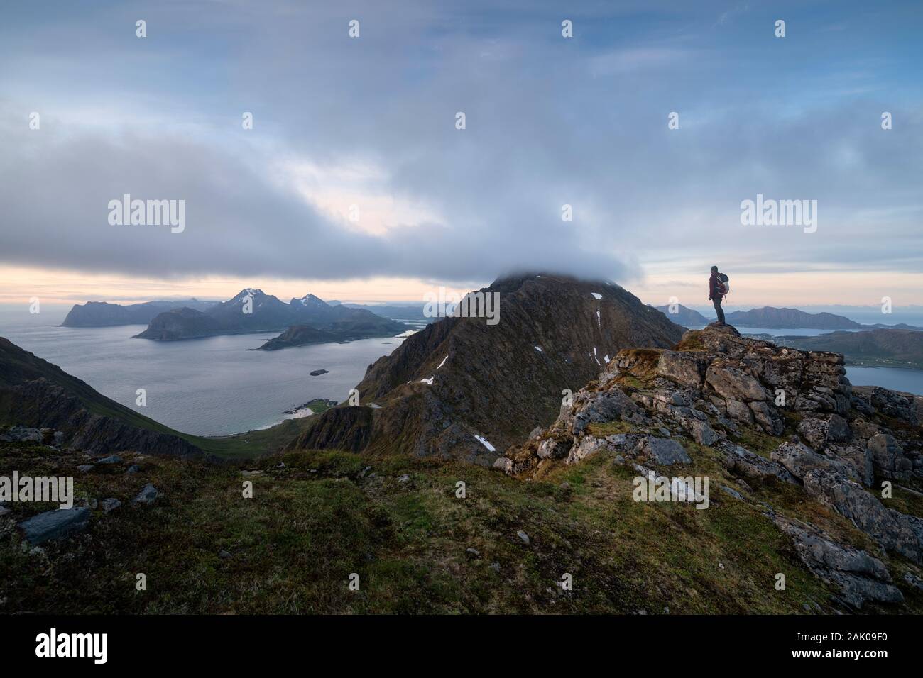 Escursionista femmina si affaccia sulla montagna paesaggio dal Middagstind, Flakstadøy, Isole Lofoten in Norvegia Foto Stock