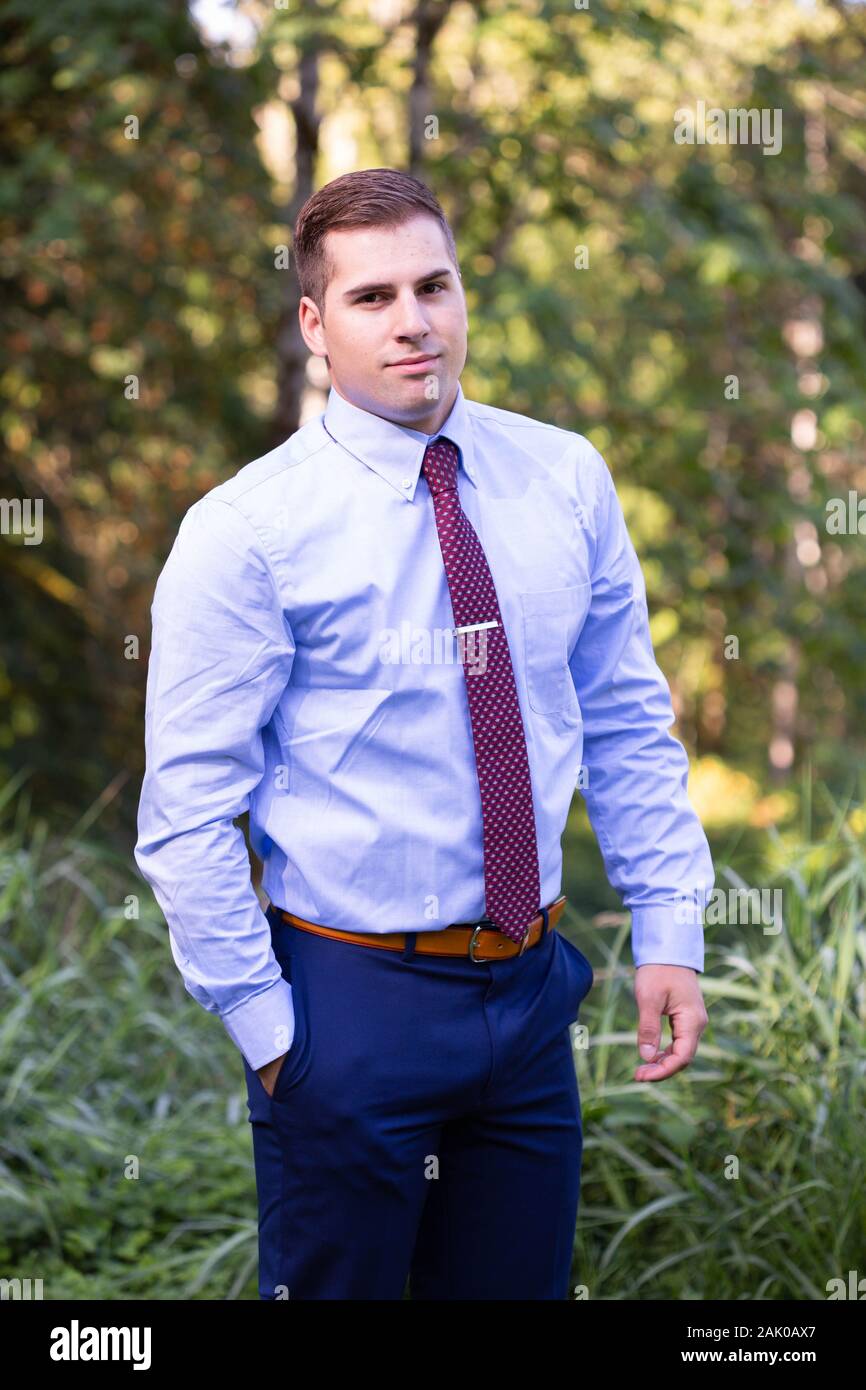 Giovane uomo sicuro in camicia e cravatta in piedi fuori. Foto Stock