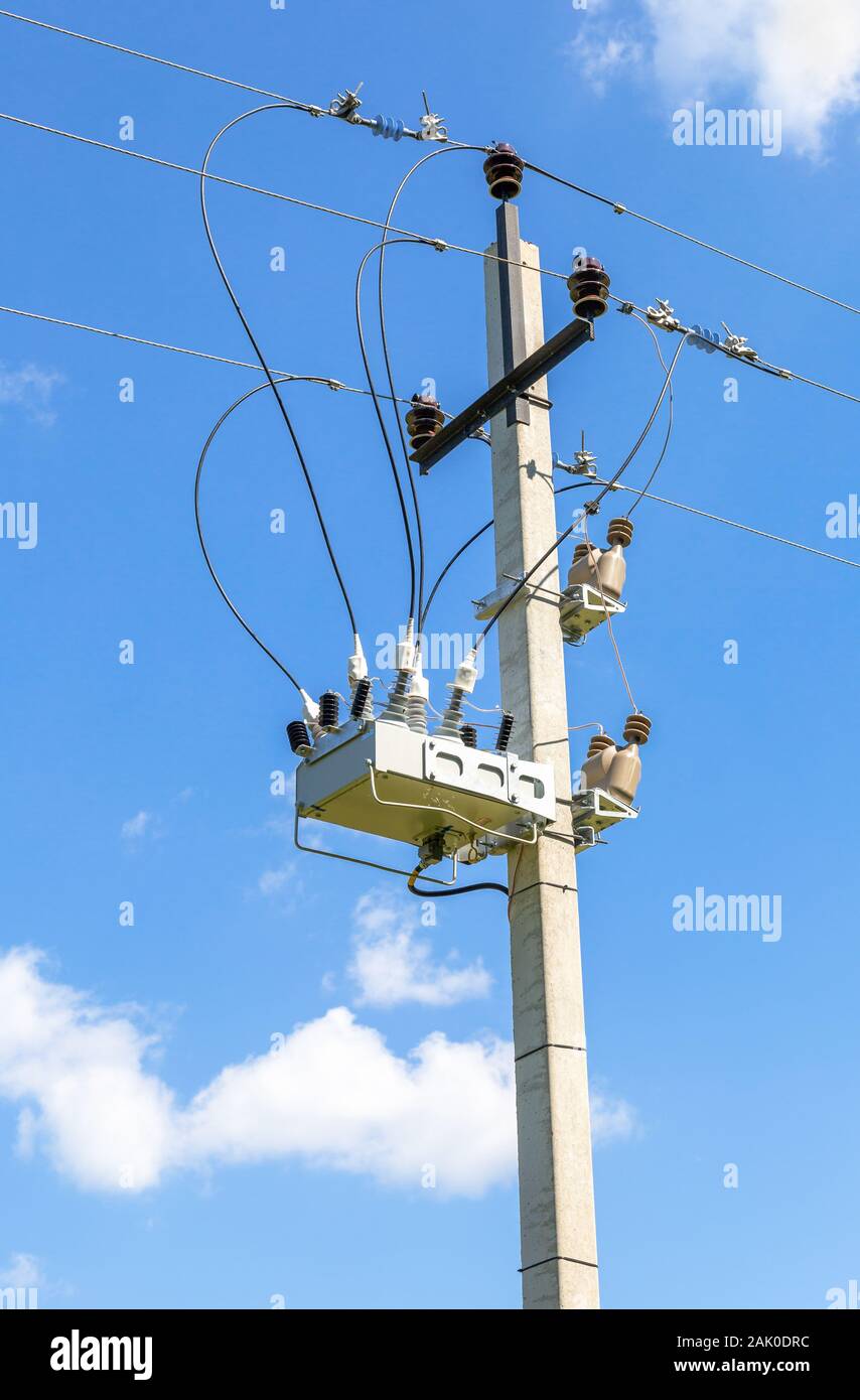 La distribuzione di energia elettrica.il trasformatore ad alta potenza stazione sul pilastro contro il cielo blu. Energia elettrica Foto Stock