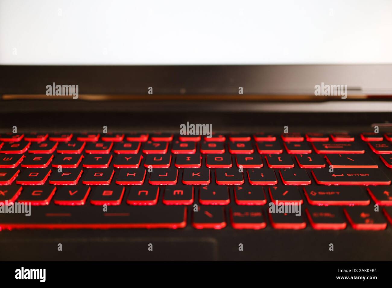 Rosso incandescente retroilluminazione della tastiera di un notebook per  videogame con il bianco mockup schermo Foto stock - Alamy