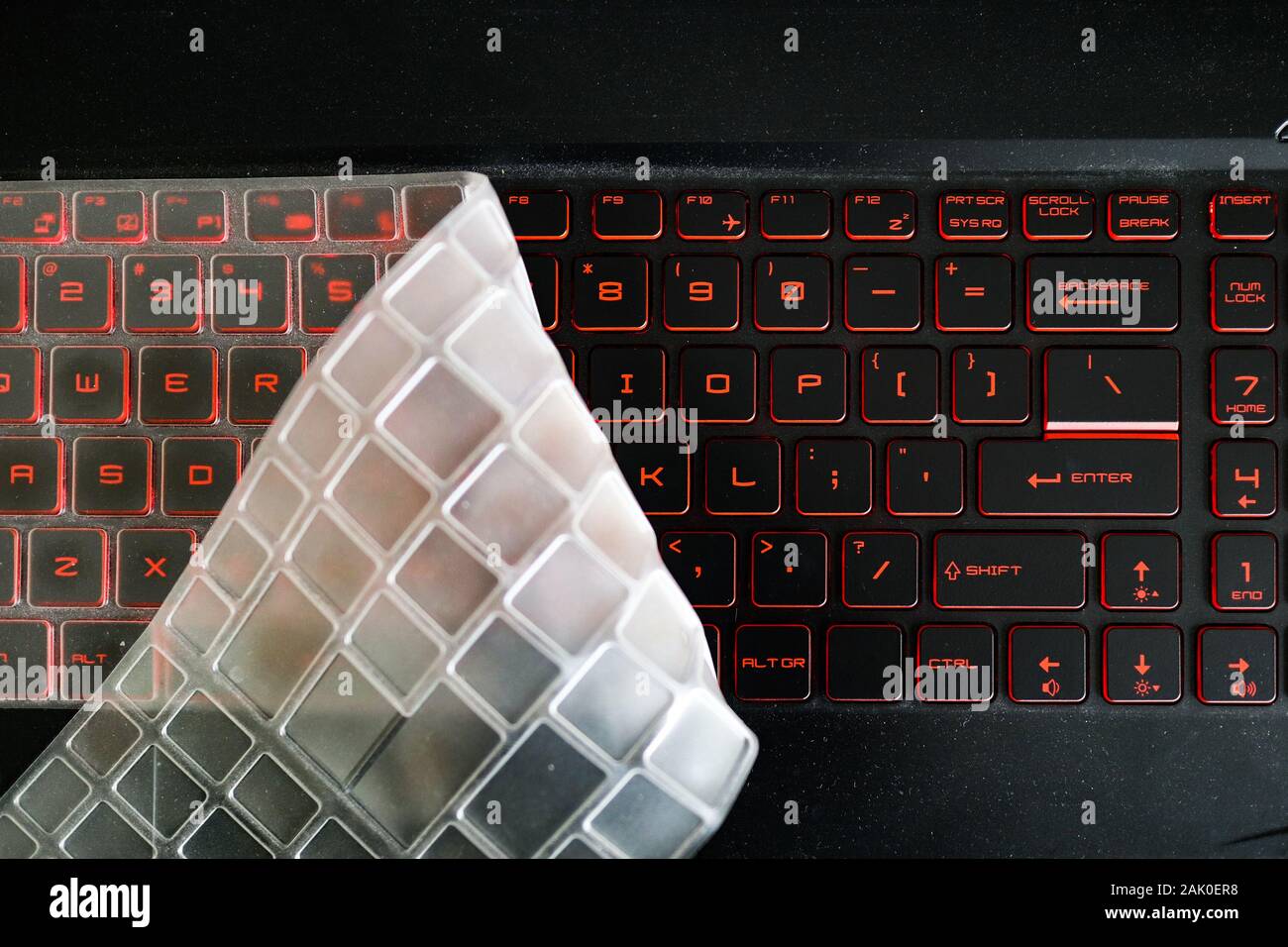 La polvere di silicio copertura tastiera ripiegata e coprendo la metà di  rosso incandescente retroilluminazione della tastiera di un notebook per  videogame Foto stock - Alamy