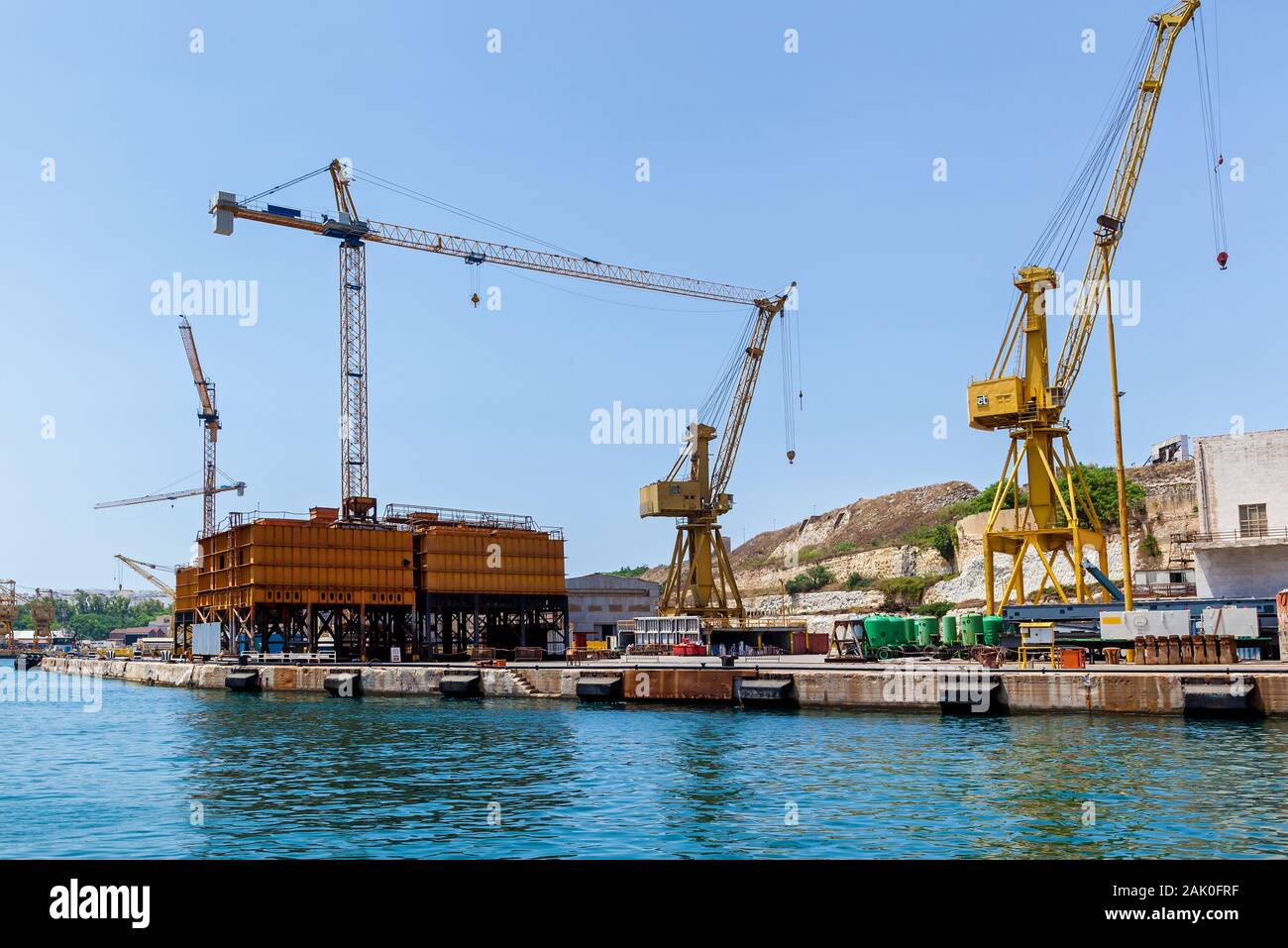 Colorata gru è posto su un bacino galleggiante nel porto di Malta. Seascape con una vista di industriale technic. Foto Stock