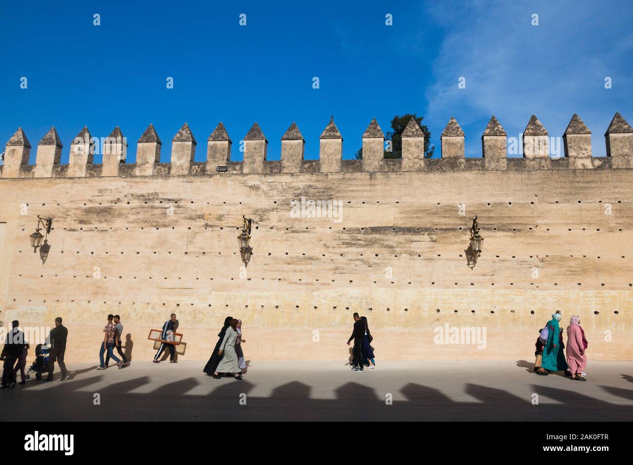 Traffico pedonale nel pomeriggio scenario di terra sbattuta le mura della città con lacune e merli nella zona di Bab Mechouar e Bab Dekkakin in Fes (fez), Marocco Foto Stock