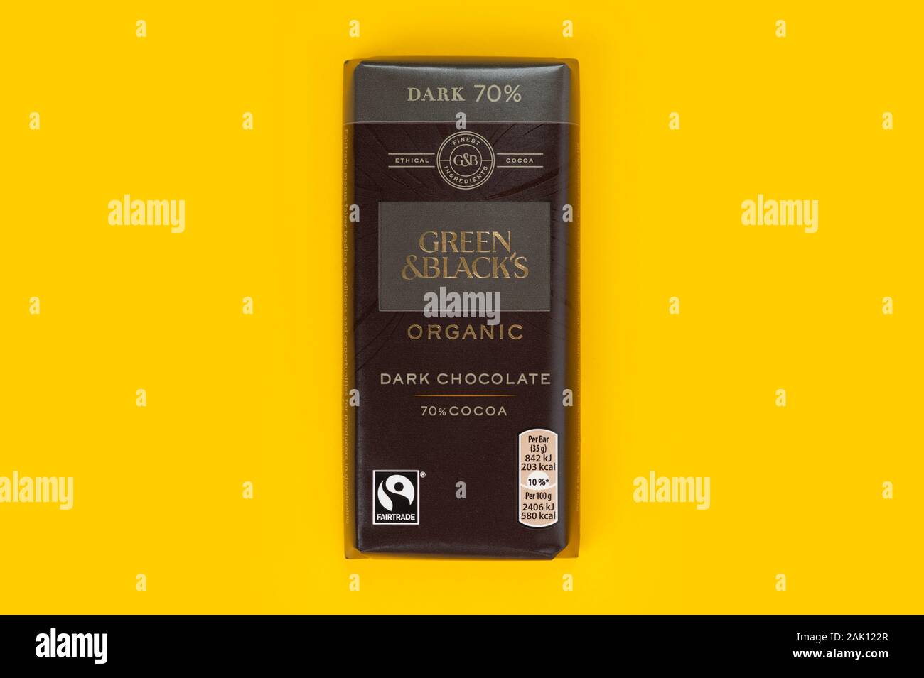Una barra di colore verde e nero dark chocolate shot su sfondo giallo. Foto Stock