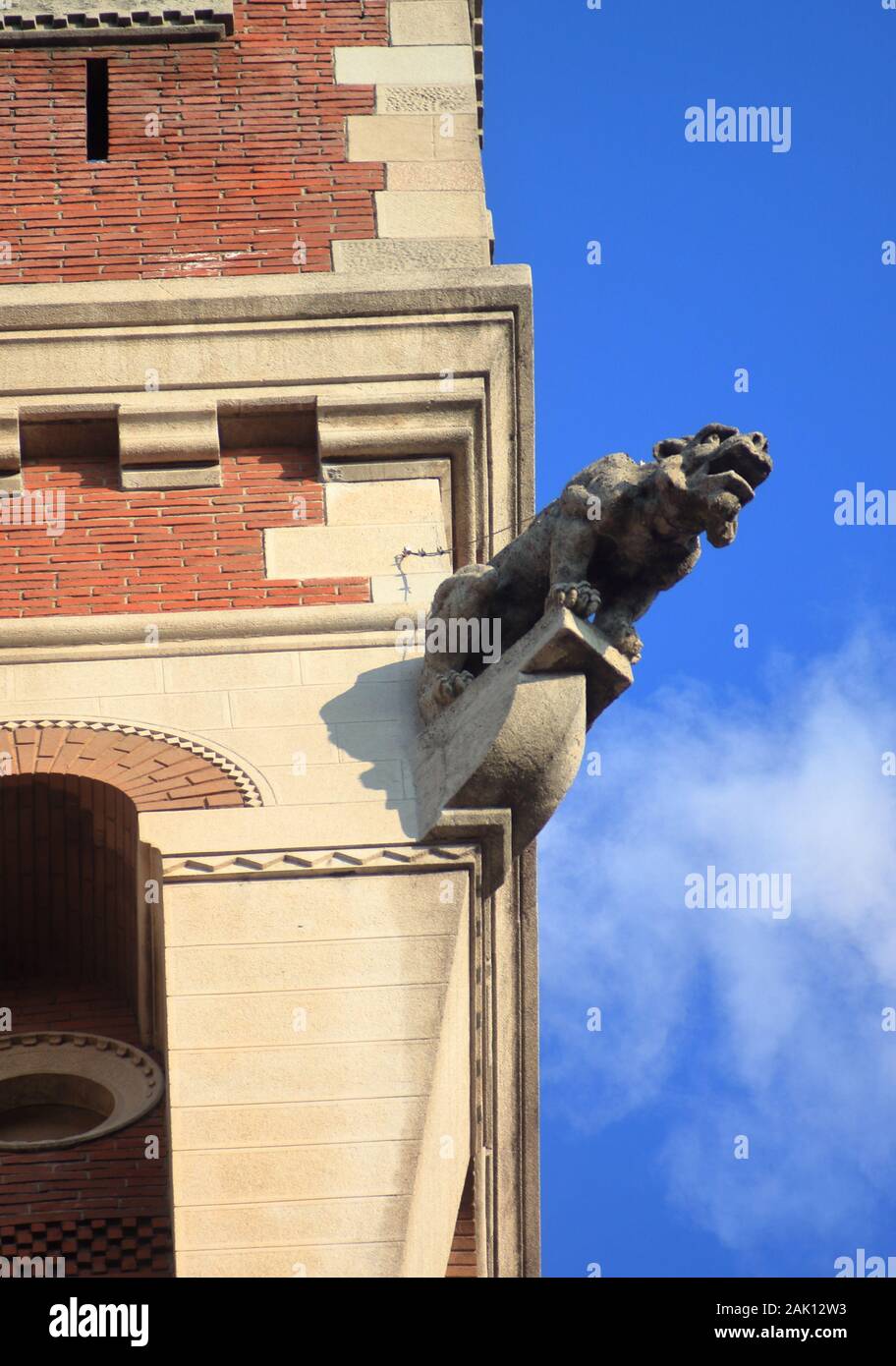 Gargoyle decorativo sulla facciata di un maestoso edificio di mattoni rossi situato a Milano Foto Stock