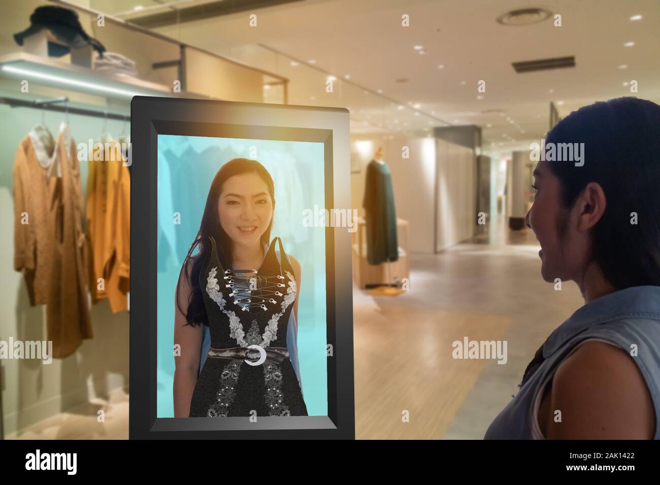 Iot smart retail tecnologia futuristico concetto, felice ragazza tenta di utilizzare smart display con virtuale o di realtà aumentata nel negozio al dettaglio o per scegliere Foto Stock