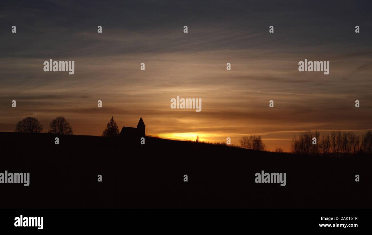 Panorama con silhouette di chiesa e tramonto sole e cielo color oro Foto Stock