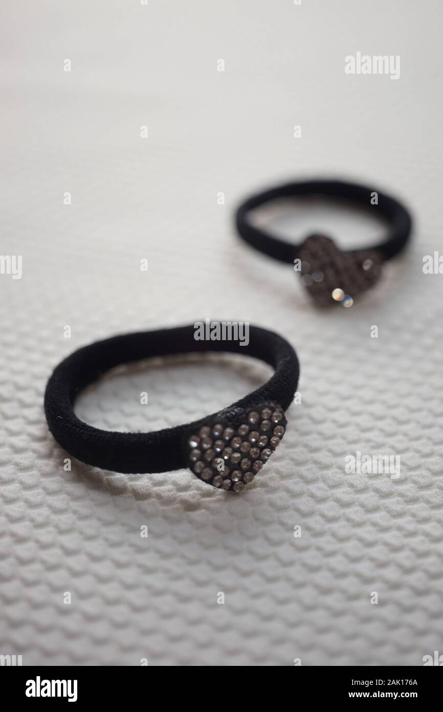 Due scrunchy per capelli con cuore nero in strass sulla superficie bianca Foto Stock