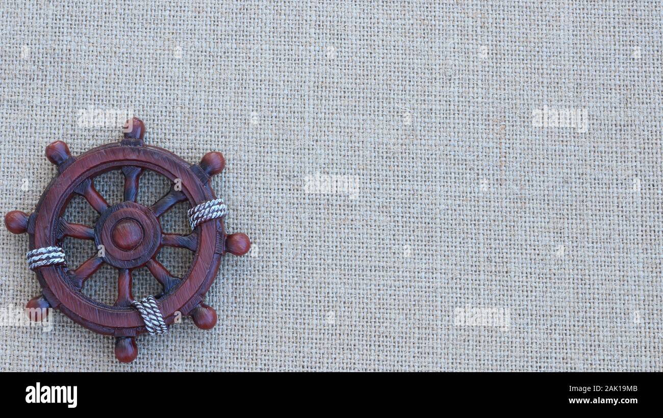 Nave di legno ruota isolata su una texture di sfondo nautico con spazio di scrittura Foto Stock