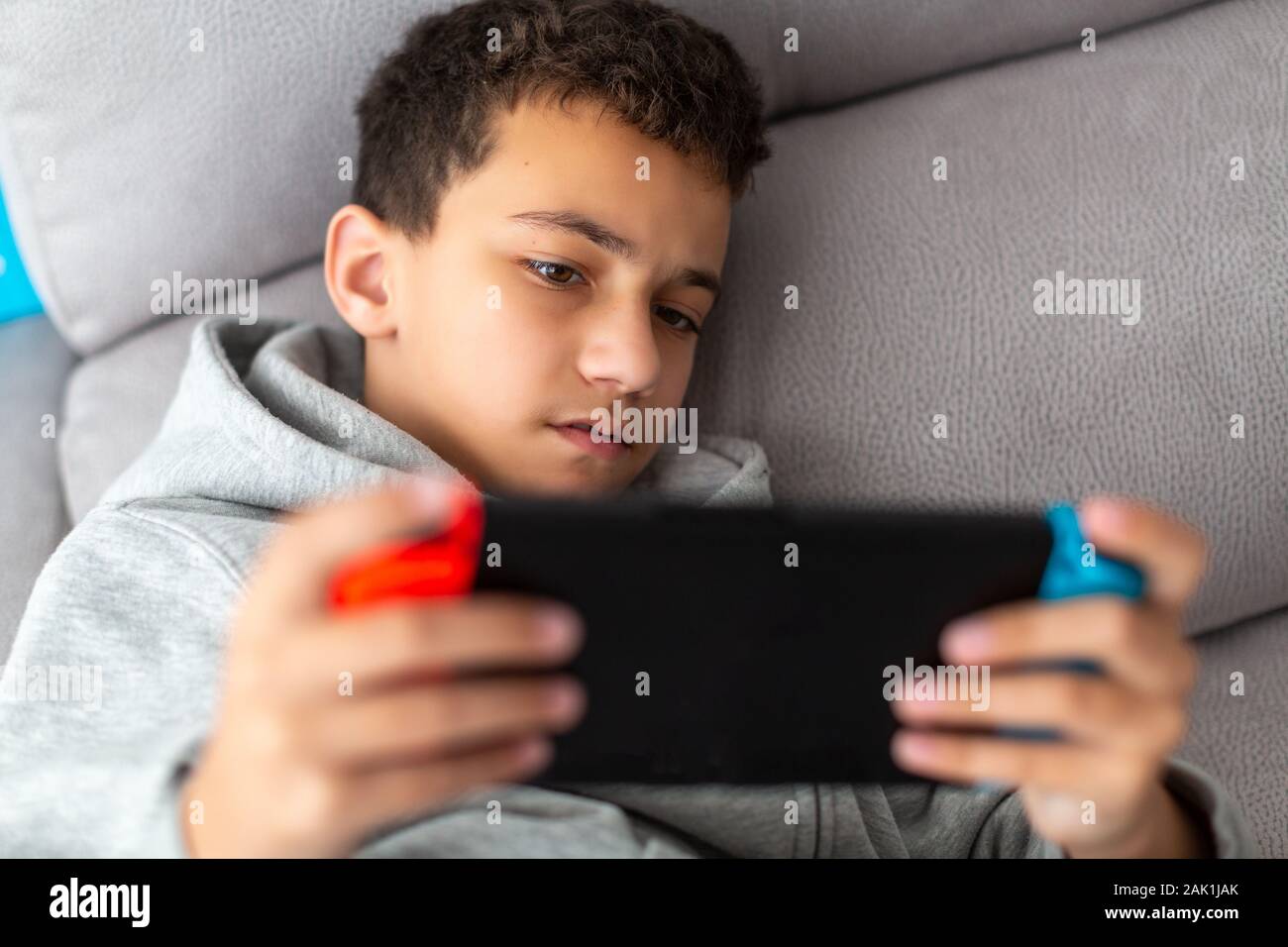 Ragazzo riproduce i video giochi su una console portatile Foto Stock