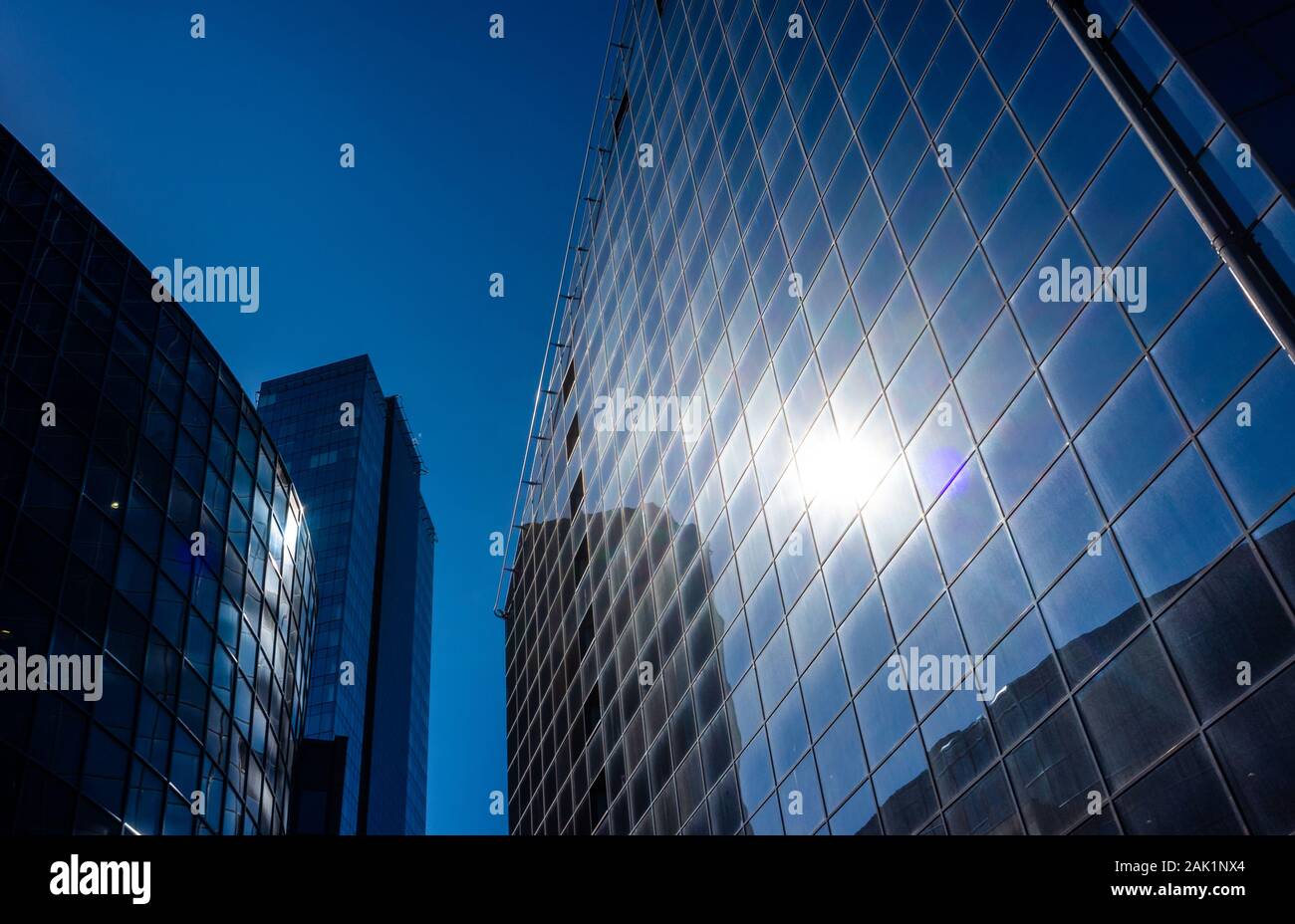 I raggi solari sono riflessi nel vetro di un ufficio moderno grattacielo Foto Stock