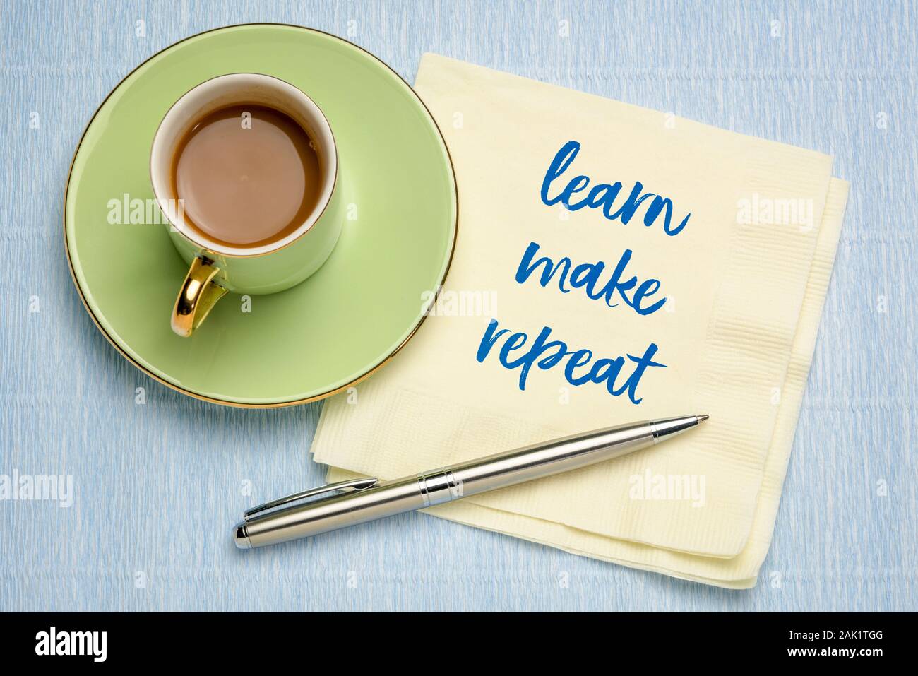 Imparare, fare, ripetere - scrittura su un tovagliolo con una tazza di caffè, ispirazione, la motivazione ed il concetto di creatività Foto Stock