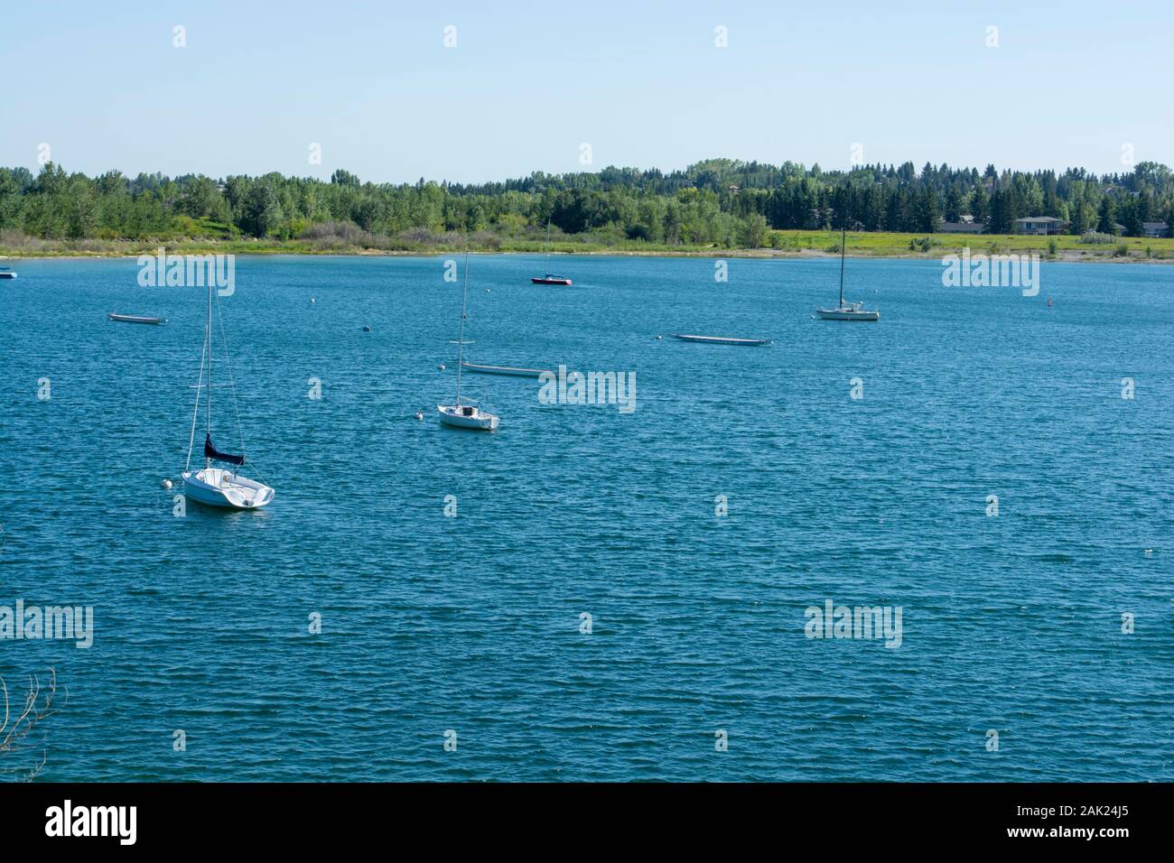 La barca a vela e barche drago da una distanza su acqua fresca lago Foto Stock