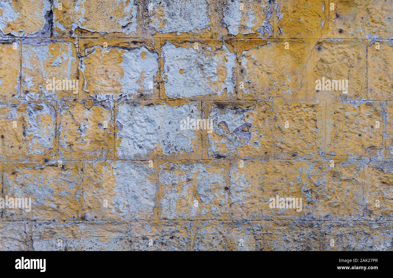 Grunge vecchio muro di mattoni dipinto di giallo il colore dello sfondo e texture. Foto Stock