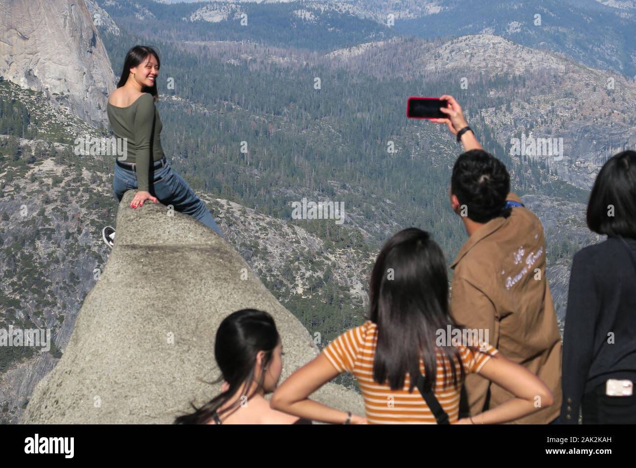 Closeup di donna climber che ha la sua foto scattata su una roccia a Glacier Point, Yosemite Foto Stock