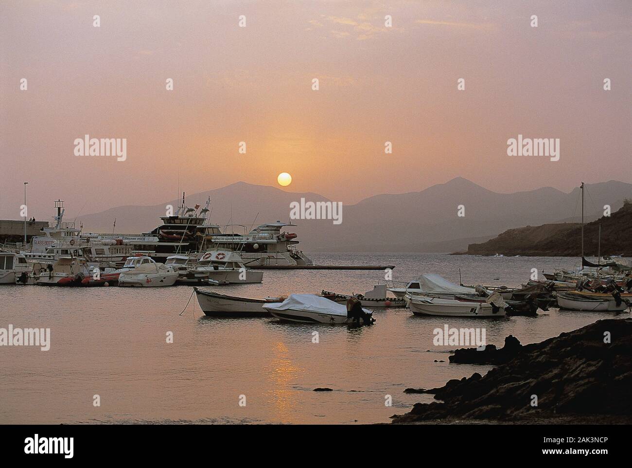 Romantica vista sul porto al tramonto in Puerta Del Carmen sull'isola spagnola di Lanzarote. Puerto del Carmen è il più importante centro di villeggiatura Foto Stock