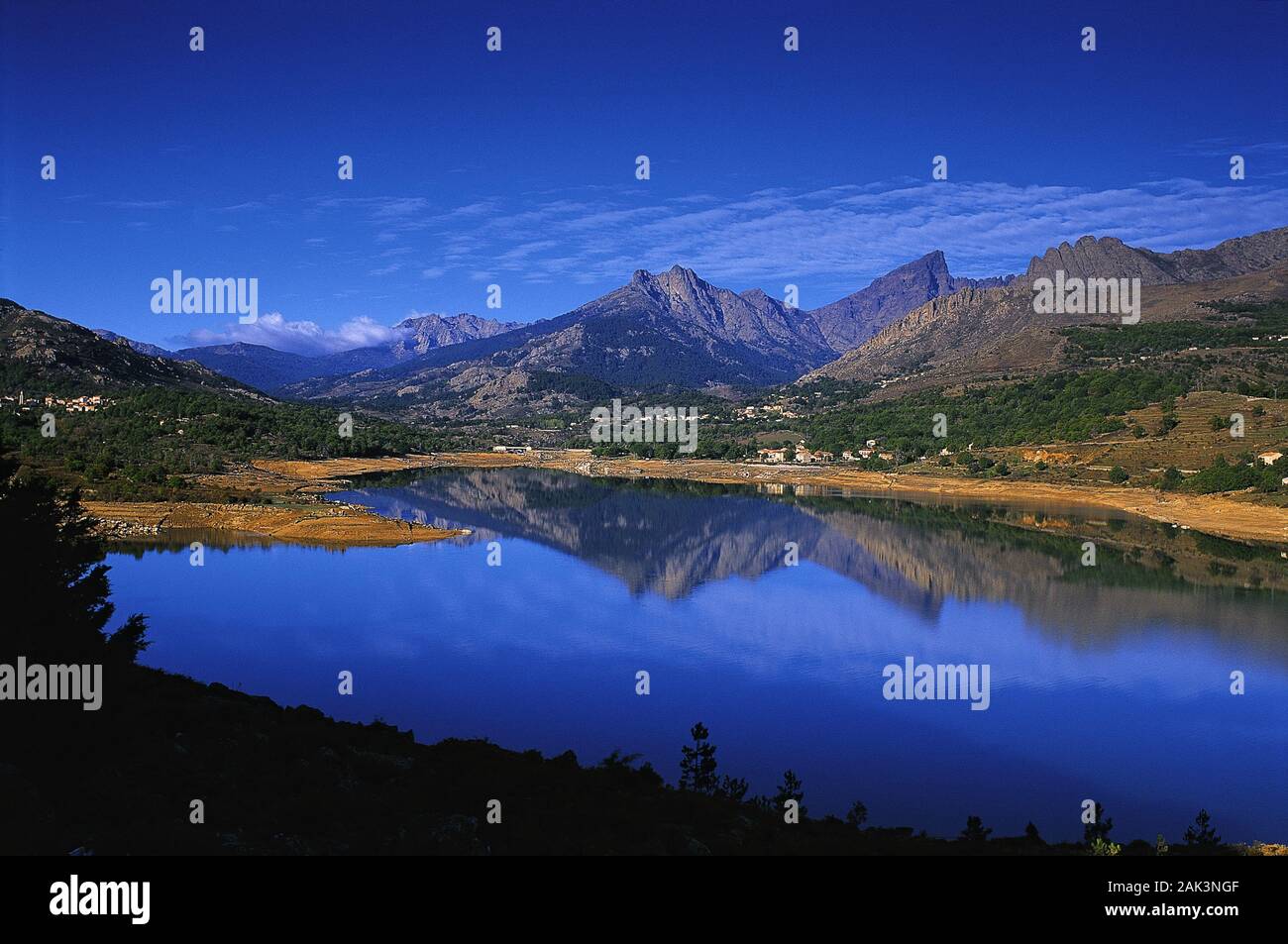 Vista pittoresca della memorizzazione vicino lago di Calacuccia sulla Corsica. I vertici acuminati della Paglia Orba e cinque frati riflettono nell'acqua del Foto Stock