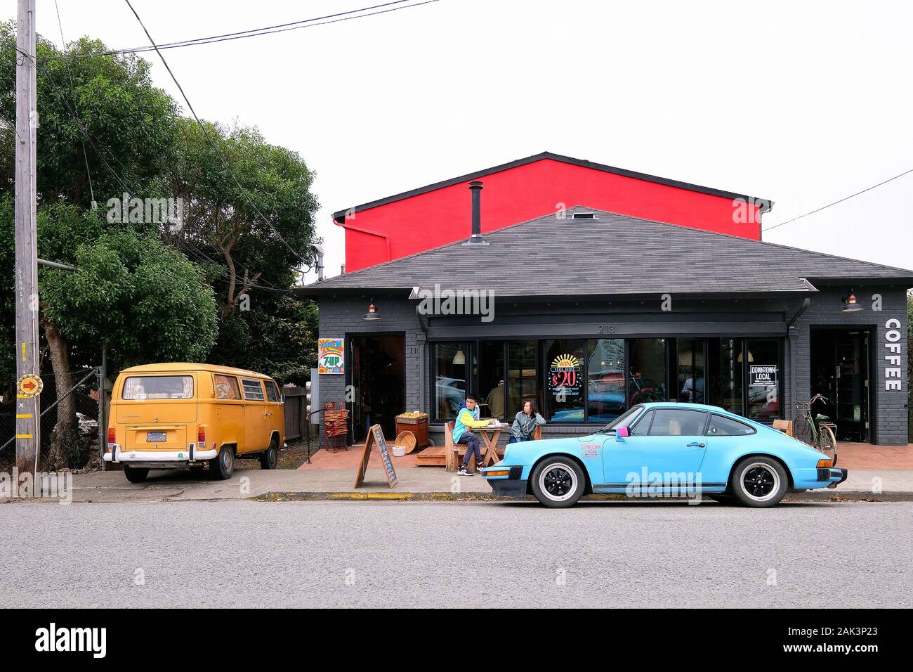 Porsche und VW-Bus vor dem Downtown cafè locale, Pescadero, Kalifornien, STATI UNITI D'AMERICA Foto Stock